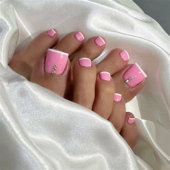 pedicure with pink base and white french tip and flowers in corner